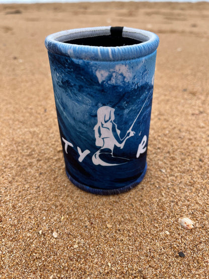 Blue cup with white design on a sandy surface